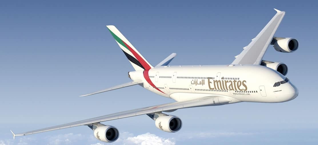 Avion Emirates survolant un ciel bleu, symbole d'un voyage luxueux avec TMR Voyages.