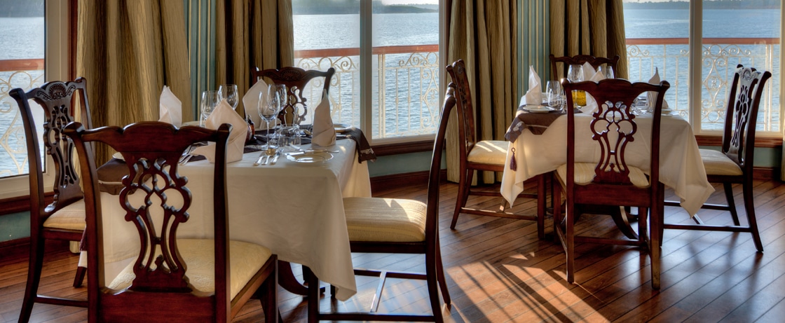 Table élégante sur un bateau de croisière, offrant une vue imprenable sur l'eau, idéale pour des expériences culinaires exclusives avec TMR Croisières.